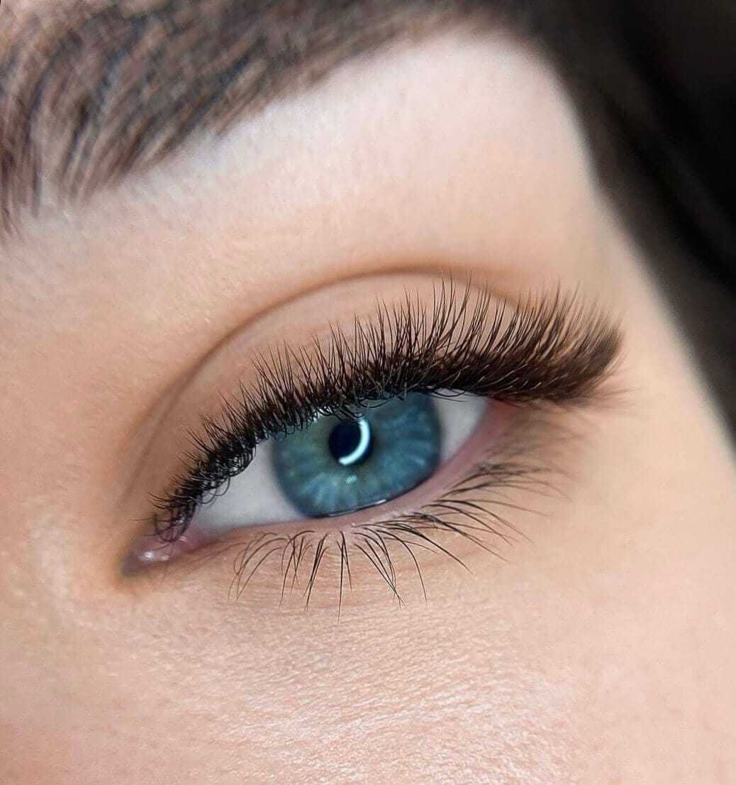 Close-up of a blue eye with long lashes and soft eyebrow.