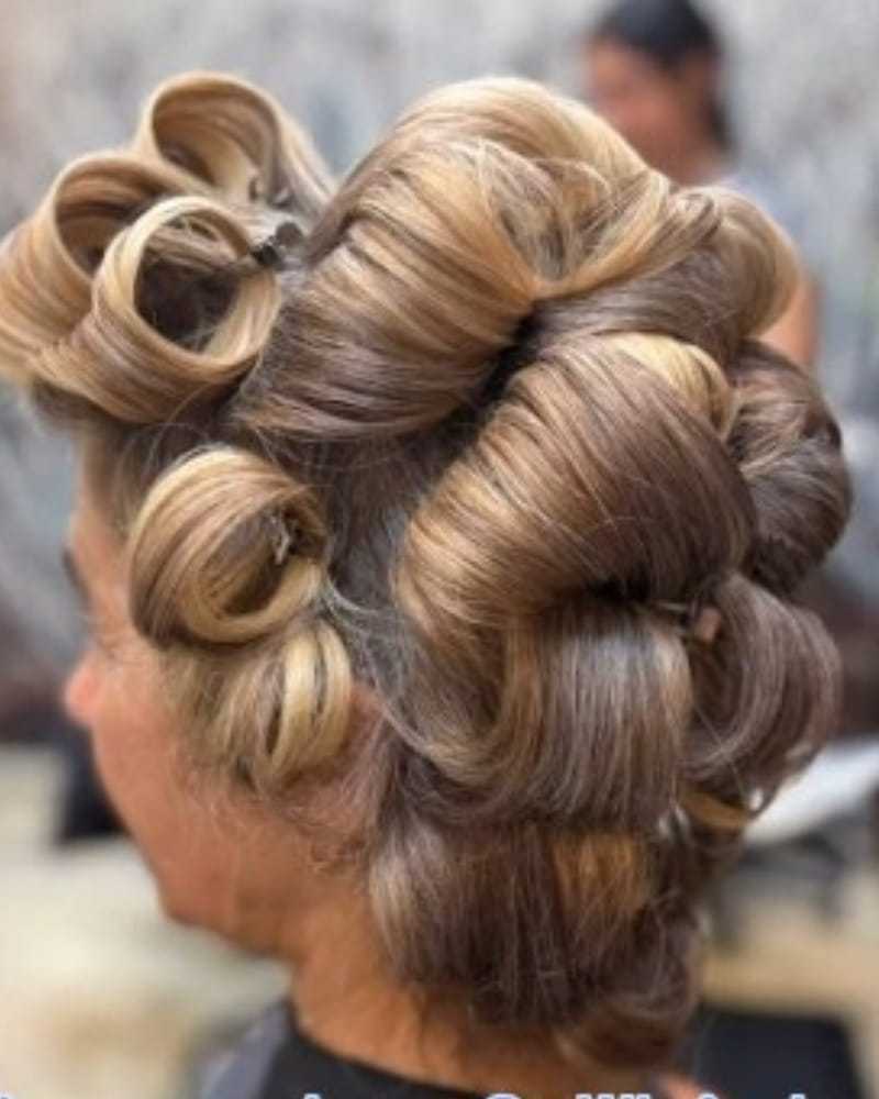 Hair styled in large curls using rollers at a salon.